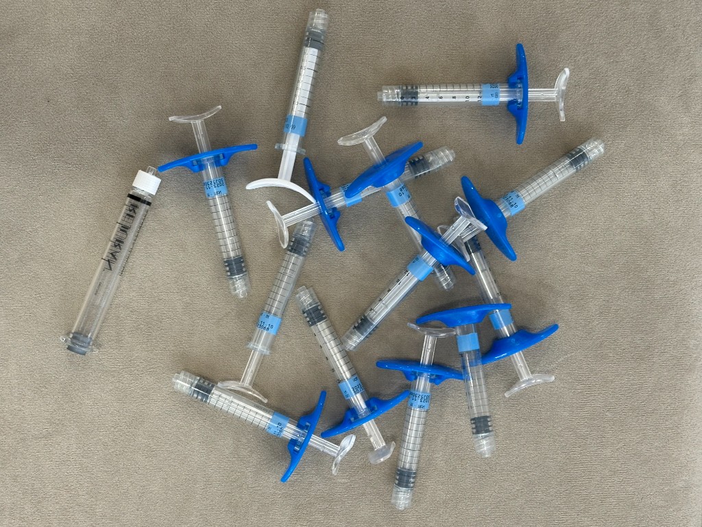 Used filler syringes photographed at Tune Clinic